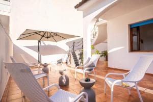 a group of chairs and an umbrella on a patio at Le Chele - A Due Passi dal Mare in Torre Lapillo