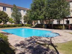 a swimming pool in front of a building at Bradclin at Mutual, Pinelands in Pinelands