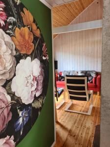 a living room with a painting of flowers on the wall at Nordfjordcabins BLUE in Utvik
