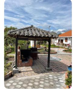 a gazebo with a roof on a patio at Quinta 4 esquinas cerca de Chachimbiro in Hacienda San Clemente