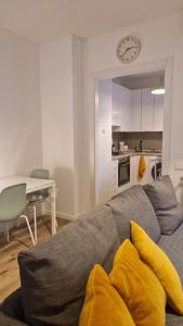 a living room with a gray couch with yellow pillows at Bandìtella home in Livorno