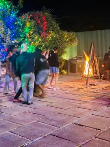 a group of people standing in front of a fire at Rivera Holiday Home in Vythiri +28 photos