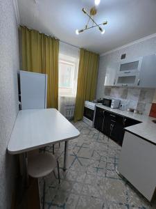 a kitchen with a table and a white counter top at 5 минут Астана Аэропорт in Prigorodnyy