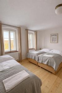 a bedroom with two beds and two windows at Pod Maliníkem in Bedřichov