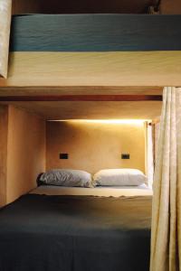 a bunk bed with two white pillows on it at SAYA Coliving in El Paredón Buena Vista