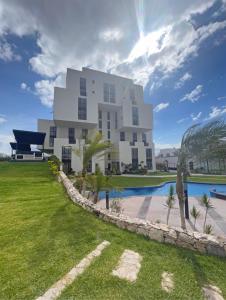 a large white building next to a swimming pool at Apartment home resort in La Cañada