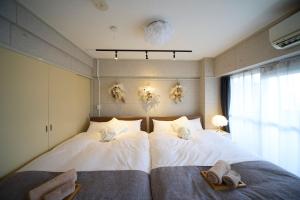 two beds in a bedroom with towels on them at Mezon Etowaaru in Nagoya +48 photos
