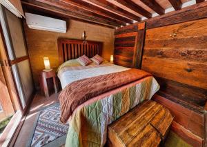 a bedroom with a bed in a wooden cabin at Casa navacoyan A in Malinalco +16 photos