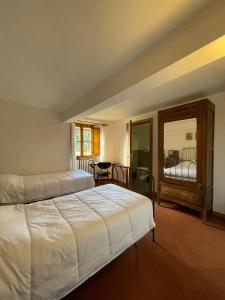 a bedroom with two beds and a table and a mirror at Casa per la Pace in Impruneta