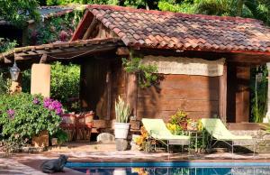 a house with two chairs and a swimming pool at Casa navacoyan A in Malinalco