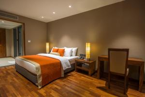 a bedroom with a bed and a desk with two lamps at Swiss Residence Kandy in Kandy