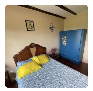 a bedroom with a bed with yellow sheets and a blue door at Quinta 4 esquinas cerca de Chachimbiro in Hacienda San Clemente +9 photos