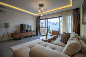 a living room with a large couch and a television at Mykonos Holiday Homes in Kyrenia