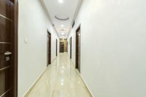 a corridor in a building with white walls and a long hallway at Treebo Greenwood Premier Suites, Old Airport Road in Bengaluru