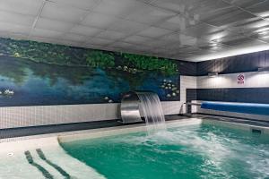 a swimming pool with a waterfall in a building at Apartamentos Spa Cueto in Cangas de Onís