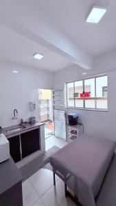 a white kitchen with a sink and a table at Achadinho no Coração de Aparecida 2 in Aparecida +22 photos