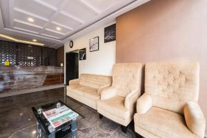 two chairs and a table in a waiting room at Treebo Greenwood Premier Suites, Old Airport Road in Bengaluru