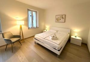 a bedroom with a bed and a chair and a window at Antico Borgo San Zeno in Bardolino