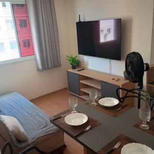 a living room with a table and a tv at MaM TORRE DOS HOLANDESES in São Luís