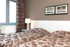 a hotel room with two beds and a window at Hotel Aguado in Dieppe
