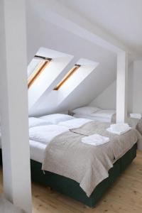 a bedroom with a bed with white sheets and two windows at Pod Maliníkem in Bedřichov +61 photos