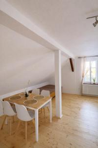 a dining room with a table and chairs and a bed at Pod Maliníkem in Bedřichov
