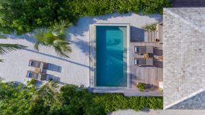 an overhead view of a swimming pool next to a building at Hurawalhi Island Resort in Kuredu