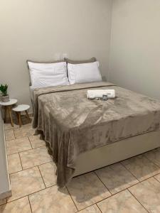 a bed with two towels on it in a bedroom at Chalés no Quintal in Alvorada do Sul