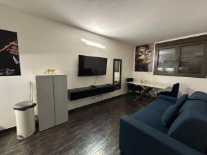 a living room with a blue couch and a tv at Résidence P&C Studio charmant in Neuilly-sur-Marne +26 photos