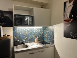 a kitchen with a sink and a microwave at Résidence P&C Studio charmant in Neuilly-sur-Marne