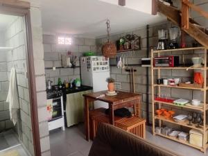 a kitchen with a table and a refrigerator at Villa Madalena Lofts in Maceió