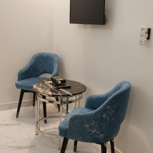 two blue chairs and a table in a room at Karachi Inn in Karachi +14 photos