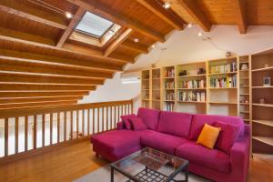a living room with a purple couch and bookshelves at Casa Flora in Garda +28 photos
