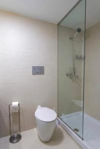 a bathroom with a toilet and a glass shower at El Pontifical in Los Santos de la Humosa +39 photos