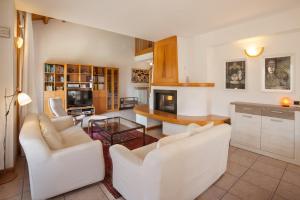 a living room with white chairs and a table at Casa Flora in Garda