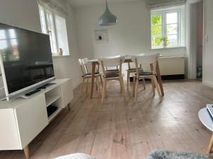 a living room with a table and chairs and a television at Linn in Oldsum