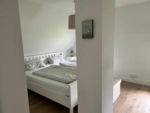 a bedroom with a bed in a white room at Linn in Oldsum