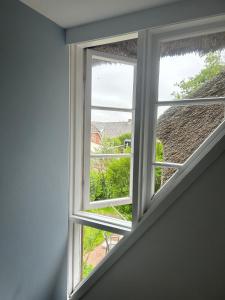 an open window with a view of a yard at Linn in Oldsum