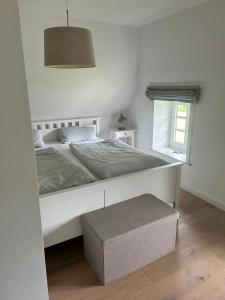 a bedroom with a large white bed and a window at Linn in Oldsum +19 photos