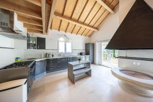 a large kitchen with wooden ceilings and a stove at Gîte familial à Jezainville - Nature, terrasses & jardin clos, Vue vallée, forêt in Jezainville +28 photos
