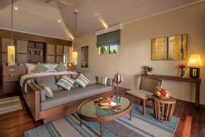 a living room with a couch and a table at Hurawalhi Island Resort in Kuredu