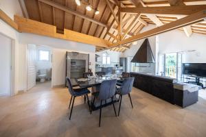 a kitchen and dining room with a table and chairs at Gîte familial à Jezainville - Nature, terrasses & jardin clos, Vue vallée, forêt in Jezainville
