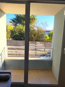 a view from the living room through the sliding glass doors of a balcony at Departamento Corcovado in Puerto Montt