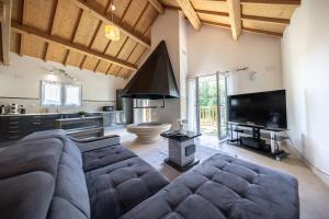 a large living room with a couch and a television at Gîte familial à Jezainville - Nature, terrasses & jardin clos, Vue vallée, forêt in Jezainville