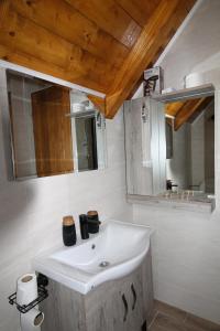 a bathroom with a white sink and a mirror at Etno Lug - Village in Bogetići