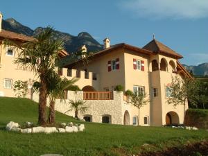 a large house with a palm tree in front of it at Leuchtenhof in Caldaro