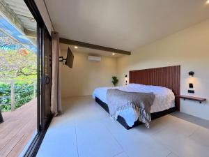 a bedroom with a bed and a large window at Roca Verde Retreats & Car Rental in Atenas +15 photos