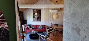 a living room with a red couch and a table at Nordfjordcabins BLUE in Utvik