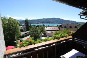 a balcony with a view of a town and a lake at Ferienwohnungen Fiala-Köfer in Pörtschach am Wörthersee