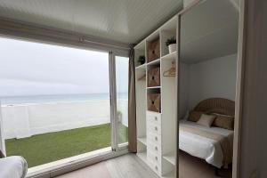 a bedroom with a bed and a view of the beach at Ed.Senses. Apto Infinity in Tarifa